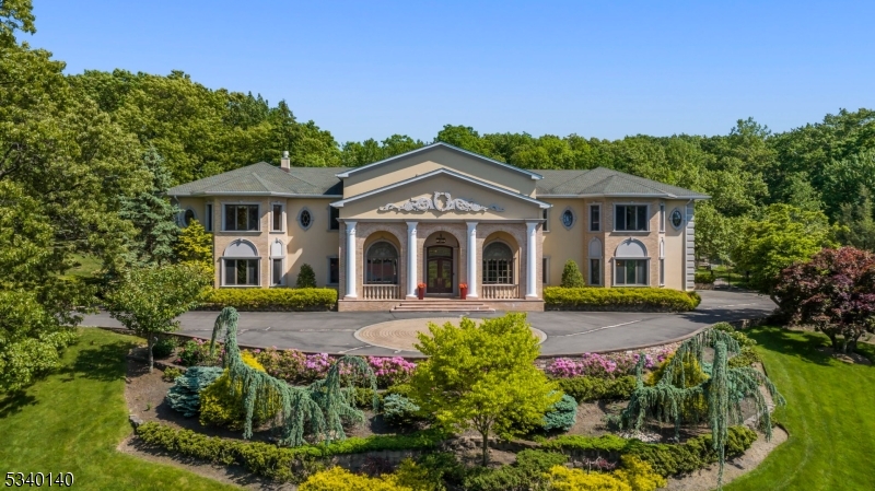 Perched atop a gated hill, this exquisite estate is a masterpiece of timeless elegance. Step inside to discover an atmosphere of refined sophistication, where extraordinary craftsmanship meets classic design. Coffered ceilings, intricate gold leaf trim, and tray ceilings adorn the interior, creating a sense of grandeur. Throughout the home, Fenestra Waldbrunn windows and doors enhance both aesthetic appeal and functionality, while dazzling imported chandeliers crafted from real crystal remain as part of this opulent offering. The 2-story dining room sets the stage for elegant gatherings, while the banquet hall complete with a custom-built bar, marble fireplace, and double French doors seamlessly extends to a covered patio. The gourmet kitchen boasts top-of-the-line appliances, wine fridge, and a built-in Miele coffee machine. The first floor also inc. a stately office w/custom-built-ins, a secondary primary suite or use as intended as a screening room, a guest bedroom, & 2 powder rooms. Ascending the grand doublewide staircase, w/custom railings, you'll find HW floors throughout each of the large bedroom's all w/ en-suites. The primary suite has 4 walk-in closets, a serene sitting area, and a spa-inspired bath w/ steam room. Beyond the interior, this estate offers resort-style outdoor amenities, including a private tennis court, an in-ground pool with a spacious hot tub, and an updated pool house. A rare opportunity to own a distinguished piece of architectural history.