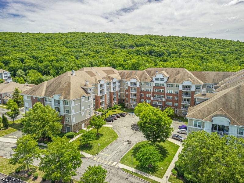 Beautiful one floor condo in one of the best locations at Wanaque Reserve, one of northern New Jersey's most prestigious 55+ active adultcommunities. This unit is on the 4th floor in building #8. It is a prime location with beautiful scenic mountain views from the windows and from the privatebalcony off the living room. It is one building away from the clubhouse and pool. This 2 bedroom, 2 bath unit has been recently painted and shows gleaminghardwood floors and freshly cleaned carpets. Hardwood floors are featured in most of the unit with carpeting in the bedrooms and den/bonus room. Thespacious dining room is great for entertaining and the french doors that lead into the den give a nice dramatic feel. Great open floor plan with plenty ofwindows and natural light. Eat-in kitchen offers corian countertops and plenty of cabinets. Laundry room off the kitchen offers full size washer & dryer. Allappliances included. The primary bedroom suite features a tray ceiling, a custom walk-in closet, second closet, and en-suite bath with double vanities.Additional features include storage, garage, and all the amenities at the state-of-the-art clubhouse offering all the resort type amenities one could wantincluding fitness facilities, social activities, indoor/outdoor pool, sauna, and tennis courts, just to mention a few. Minutes from highways and transportation.Close to parks, shopping, and restaurants. Easy commute to NYC. You won't be disappointed! Book your appointment today.