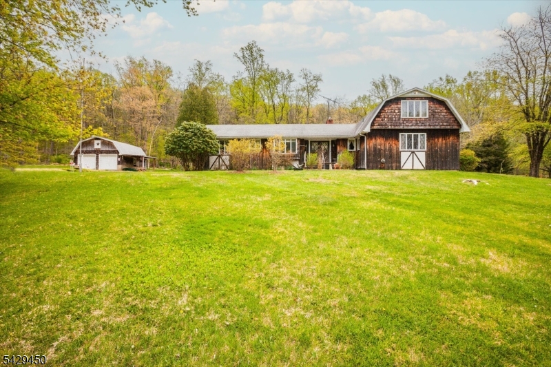 Vintage 5-bedroom, 4-full-bath home on an open, private lot in the Frog Hollow section of Califon. Solid construction, well kept and maintained, and being sold strictly in AS-IS condition. Open living and dining area with a woodstove and a full basement with workshop space offer excellent potential for creative renovation or investment for buyers with a vision. Open grounds provide possible farmette use, with a garage structure that may be converted back to a barn if desired. Pool is integrated into the deck area, and the property benefits from a desirable country location with convenient access to nearby town centers and commuter routes.
