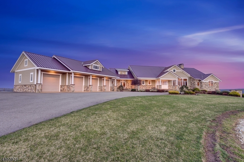 Set atop approximately 50 private acres with sweeping panoramic views of the surrounding countryside, this offering presents a rare opportunity in western New Jersey. Spanning over 8,200 square feet, the custom-built residence is thoughtfully positioned to capture its elevated setting, delivering a level of privacy, scale, and natural beauty seldom found in this market.What sets this property apart is not simply the home itself, but the irreplaceable combination of land, topography, and infrastructure. Unlike many homes whose value is concentrated solely in interior finishes, this estate offers substantial acreage, true long-range views, established equestrian amenities, and multiple Morton outbuildings providing exceptional flexibility for collectors, hobbyists, business use, or expanded recreational pursuits.Designed as a true estate residence, the home features expansive living spaces, generous garage capacity, and interiors oriented to maximize the surrounding vistas. The acreage offers both privacy and usability ideal for equestrian pursuits, outdoor recreation, or simply enjoying the exclusivity of a large landholding.This is a property whose value lies in attributes that cannot be replicated: meaningful acreage, commanding elevation, extraordinary privacy, and infrastructure already in place. Opportunities to acquire a property of this scale, setting, and versatility are increasingly rare in today's market.