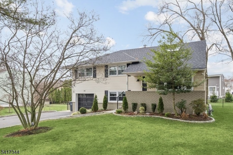 Beautiful and completely renovated Split Level Home just waiting for you to move in and enjoy! With 4 bedrooms, 2 1/2 bathrooms and designer details throughout, all set on a corner lot with convenient access to schools, shopping, dining, parks and major highways. Just minutes from 3 Direct Train Stations to New York City . Past an inviting front porch and foyer, the main level opens with gleaming hardwood floors and recessed lighting in the spacious living and dining rooms. Just beyond the beautiful kitchen with classic white cabinets, SS appliances, gorgeous quartz counters, subway tile backsplash and peninsula with extra seating. Wood floors continue upstairs to 3 bedrooms, all serviced by a full hall bath with storage vanity and a tub/shower combo with marble tile and oil-rubbed bronze fixtures. A huge, tranquil primary suite on the top-level features plush carpet, recessed lighting, skylight, 3 closets, sitting area, and an adjoining beautiful en-suite bath with shower. The ground level offers a family room with access to the attached 1-car garage and a big laundry room with outside entry and adjoining half bath, while a pristine basement level houses the utilities. A new paver patio accessible from the dining room & lower level leads out to a sprawling backyard surrounded by mature plantings for privacy, providing ample space for cookouts, relaxing & entertaining. 2023 Roof, Doors, Furnace, AC, Water Heater & more. Nothing to do here but unpack!