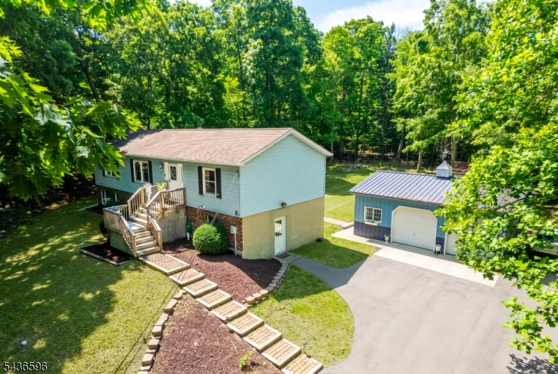 Nestled on 1.82 private wooded acres in Frankford Township, this beautifully maintained ranch offers the perfect blend of comfort, privacy, and versatility. Featuring 4 bedrooms, 3 full baths, and gleaming hardwood floors, this home welcomes you with an open and inviting layout ideal for everyday living and entertaining.The updated kitchen boasts granite countertops, abundant cabinetry, tile flooring, and a center island, flowing seamlessly into the dining and living areas. The spacious primary suite serves as a true spa-inspired retreat with a custom oversized walk-in shower, frameless glass enclosure, built-in bench, dual granite vanities, and heated tile floors.Enjoy peaceful mornings or evening gatherings on the screened porch overlooking the serene wooded setting. The level backyard offers exceptional outdoor space with multiple storage sheds, exterior lighting, and electric service to both the garage and shed.Car enthusiasts, hobbyists, and contractors will appreciate the oversized detached 2-car garage/workshop, additional outbuildings with electric, and ample parking. The finished walkout lower level provides flexible living space for recreation, guests, or a home office.Additional highlights include a private well, 3-bedroom septic, hardwood flooring, granite kitchen with center island, screened patio, and the rare combination of usable yard space and wooded privacy. A unique property offering room to live, work, and play all in a peaceful country setting.