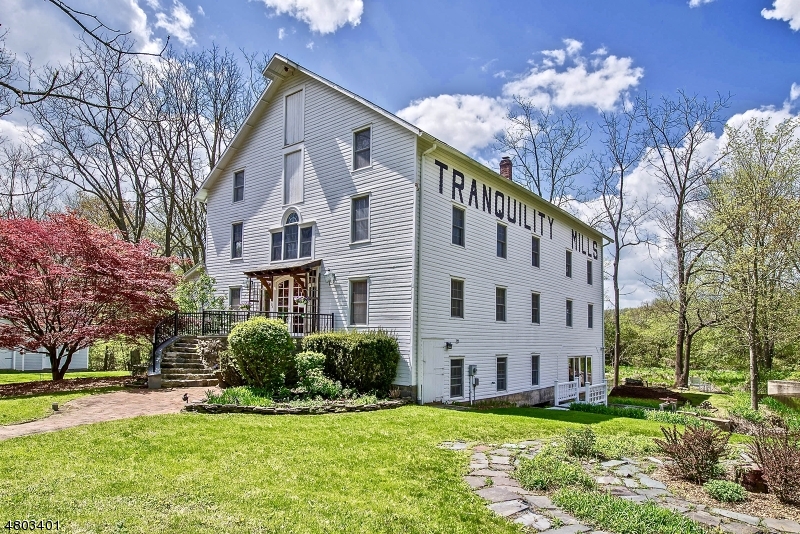 An architectural masterpiece a 10,000 s.f. grain mill built in 1844, with a one of a kind, 3,900 s.f, 3 story home located inside, designed and built by an architect. The building sits alongside the trout stocked Pequest River on a natural 2.7 acre site. Built in the craftsman style, there are 4 bedrooms and 3 baths among the grist stones, milling machines, cider presses and heavy timber of a bygone era. The third floor has a master bedroom suite. The bedrooms look out to a waterfall that creates the adjoining 19 acre mill pond. There is plenty of extra space to expand for an artisan workshop or home office. Sleep, work or splash to the sound of the waterfall!