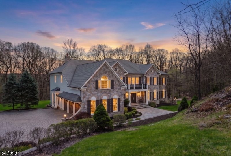 Step into timeless elegance and modern comfort in this stunning colonial set on a beautifully landscaped 1.7-acre property. A grand butterfly staircase and soaring ceilings welcome you into a bright, open layout designed for both entertaining and everyday living. Refined details include coffered ceilings, custom millwork, bespoke architectural detailing, crown molding, expansive room sizes, and abundant natural light throughout. Impeccably finished to the highest standard with luxury-grade materials, this home offers 6 spacious bedrooms, including a flexible guest suite or playroom, 5 full baths, and a powder room for exceptional versatility. The gourmet kitchen features granite countertops, custom cabinetry, a center island, double ovens, and a wine cooler?ideal for gatherings large or small. Enjoy cozy evenings by one of two fireplaces or unwind in the sunlit conservatory and solarium. A full unfinished walk-out basement with French doors to the patio offers endless potential for recreation, fitness, or additional living space. The exterior showcases premium stone construction (no vinyl siding), a high-end stone/paver driveway, and wooden garage doors. Outdoor living shines with a stone patio and fire feature, two new modern decks, a backyard play area, and newly replaced windows. Located in sought-after Sparta, enjoy a luxury lifestyle with golf, boating, dining, and year-round recreation?just 60 minutes to NYC. ALL Furniture available for purchase.