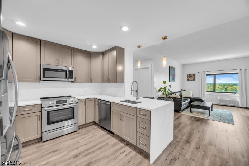 Welcome to a fully renovated 2-bedroom, 2-bath condo on the 16th floor of Skyview (Unit #1620).  Bright and spacious with stunning city views, this home was completely updated in 2022 and offers modern open-concept living. The kitchen features stainless steel appliances and flows seamlessly into the living area- perfect for entertaining. Both bathrooms are generously sized and thoughtfully updated, including a primary suite with a walk-in shower, and double sink vanity.  Split bedrooms floor plan for privacy.  Fitness center, rooftop terrace with panoramic views of the Manhattan skyline ! Direct connection to the Watt Hotel's bar and restaurant. Sewer, water, trash collection and snow removal included in HOA.  upgrades include a new washer and dryer (2022), and New AC units (2023), gray shaker cabinets, quartz countertops ,  Aged Oak scratch resistant laminate wood flooring.  Located in the heart of Rahway, steps from NJ Transit, enjoy direct access to Manhattan,  garage parking ($120/month per car),lounge.  This move-in-ready home combines style, comfort, and breathtaking views in one exceptional package. Sewer, water, trash collection and snow removal are covered by HOA fees. Pet Friendly.
