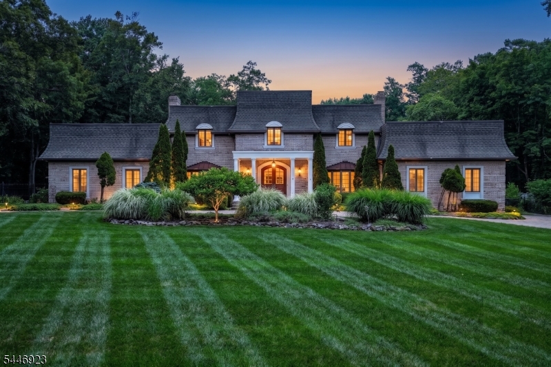 A rare offering in one of Saddle River's most coveted enclaves, this exquisite 6-bedroom French Provincial estate is tucked at the end of a private cul-de-sac, offering exceptional privacy and a resort-like lifestyle. A grand entry with a sweeping dual staircase creates a stunning first impression, setting the tone for the elegant interiors throughout. The magnificent grounds are a horticultural masterpiece with enchanting country gardens, vibrant perennial blooms, specimen plantings, fruit trees, herbs, and a tranquil winding koi pond home to more than 40 colorful koi. Designed for entertaining and everyday living, the secluded backyard showcases a custom outdoor kitchen, expansive paver terraces, a heated gunite pool and spa, and a charming two-story barn with fenced paddocks, ideal for equestrian pursuits, collector vehicles, a guest retreat, or an exceptional entertainment space. Renovated bathrooms feature high-end finishes, designer fixtures, and spa-inspired details.  The oversized 3+ car garage easily accommodates a vehicle lift, while the expansive paver drive provides parking for 8+ vehicles. Timeless French Provincial architecture, luxurious finishes, extraordinary outdoor amenities, and unmatched privacy combine to create a one-of-a-kind estate offering an exceptional lifestyle in one of Bergen County's premier luxury locations.