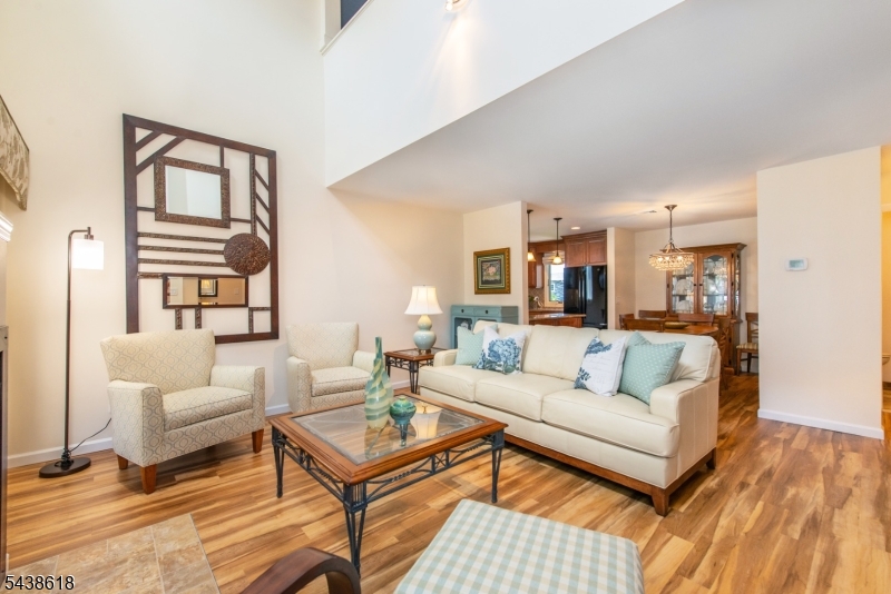 Move right into this beautifully updated 2-bedroom, 1.5-bath top-floor end-unit condo in the desirable River Renaissance community. Featuring soaring vaulted ceilings, an open-concept layout, and numerous recent updates, this home offers the perfect blend of style, comfort, and convenience. Freshly painted in 2023, the home features new flooring (2024) throughout the first floor. The bright living area includes a cozy fireplace, powder room, and sliding doors leading to a deck with low-maintenance Trex decking. The renovated kitchen showcases granite countertops, custom walnut cabinetry, and a new GE refrigerator and dishwasher (2026). Upstairs, the spacious primary bedroom offers double closets, while the loft-style second bedroom, currently used as a den/family room, overlooks the living room below and creates an open, airy feel.  The stunning renovated main bath features a custom design, natural quartz countertops, large stall shower and a newer washer and dryer (2022) conveniently hidden behind a closet. Additional highlights include central AC, a tandem two-car garage with interior building access, storage and ample guest parking throughout the community.  Conveniently located near parks, shopping, dining, public transportation, and major highways, this home benefits from low HOA fees and is part of a well-maintained community with strong HOA management and a no-pet policy. Stylish, low-maintenance living in a prime location. This one won't last!
