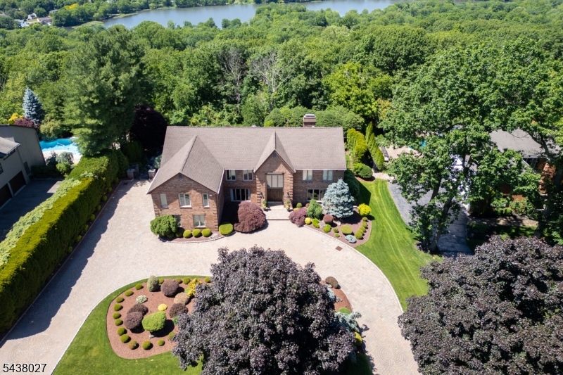 Don't miss this masterfully renovated estate in the most desirable Shongum section of town. From the moment you pull into the circular brick-paver driveway, the curb appeal and meticulous landscaping set a tone of pure elegance. Inside, the home unfolds with a dramatic entry that leads to a custom formal dining room featuring curved walls. The open-concept home flows seamlessly from the living room into a soaring great room with a custom fireplace. The designer kitchen belongs on a magazine cover. You?ll love the massive picture window over the sink, framing serene views of your private backyard oasis. The backyard is a showstopper. Whether you?re lounging by the gunite inground pool, hosting on the paver patio, or relaxing on the deck under the retractable awnings, it feels like a year-round vacation. The primary suite is a true sanctuary, complete with an updated spa-like ensuite bath featuring furniture quality cabinetry, jetted tub, stall shower and sauna. The custom closets complete the primary suite. Downstairs, the finished walk-out lower level adds incredible square footage, featuring a media room, office, gym, full bath, and built-in wet bar for entertaining. Tucked away on a quiet cul-de-sac with public utilities and easy access to downtown Morristown and the NYC train, this home offers the perfect blend of high-end luxury and everyday convenience. It?s rare to find a property where every single detail has been attended to with such care.