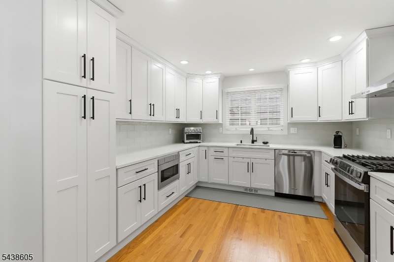 Welcome to this beautifully maintained 2,190sq.ft., move-in-ready Colonial built in 2005, offering modern updates, spacious living, and a prime location. This home features 4 bedrooms, 3.5 baths, a first-floor primary suite, and a stunning kitchen renovation completed in 2025.The bright main level includes an inviting foyer, spacious living room with fireplace, formal dining room, powder room, and an updated eat-in kitchen with abundant cabinetry, storage, and backyard access perfect for entertaining and everyday living. The first-floor primary suite offers a large walk-in closet and updated private bath. Upstairs are three generously sized bedrooms, all with walk-in closets, and a recently renovated full bathroom. The fully finished basement expands the living space with impressive 12-foot ceilings, a full bath with shower, separate laundry room, gas freestanding fireplace, and versatile bonus space ideal for a home office, gym, recreation room, media room, or guest area. Additional features include hardwood floors throughout, crown molding, central air, a finished garage with direct home access, and a low-maintenance paved backyard. Conveniently located on a 40x100 lot just two blocks from NJ Transit train and bus service to NYC, plus nearby schools, parks, shopping, and dining.A rare opportunity to own a newer Colonial with three finished levels of living space in one of Union County's most commuter-friendly locations. Truly move-in ready!