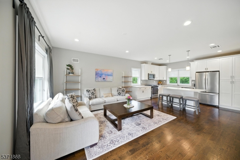 Welcome to the Brownstones at Fairfield! Built in 2018, this 3-level end-unit townhome offers modern living with hardwood floors, energy-efficient windows/doors, tankless hot water heater, and multi-zone heating/cooling. The first level features a foyer, garage entry, laundry room, storage, and backyard access. The open-concept second level offers a white shaker kitchen with quartz counters, center island, pantry, living room, powder room, and balcony. The third level features 2 ensuite bedrooms. The primary suite includes double closets with custom built-ins and a luxury bath with oversized tile shower and quartz vanity. The second ensuite offers a full bath and a closet. Top Rated Schools. Minutes to NYC transit, shopping, and major highways. Not in a flood zone.