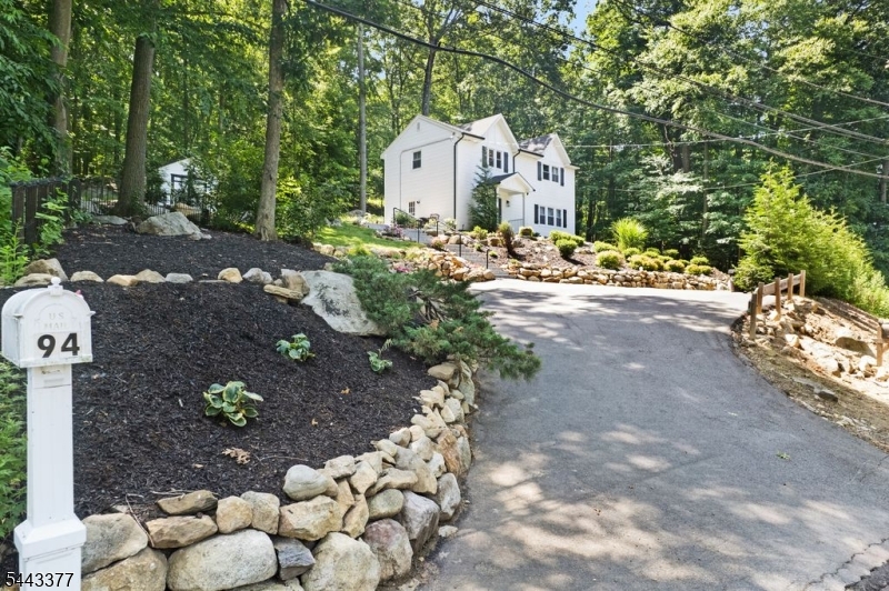 Welcome to Lake Life! Enjoy seasonal lake views from this beautifully renovated (2022) custom-style 3-bedroom home that's truly move-in ready. A welcoming front entry opens to a versatile great room with an open-concept layout, featuring a custom built-in bench and hooks for a convenient mudroom. The stunning kitchen showcases beautiful cabinetry, stylish countertops, and a large center island perfect for meal prep, casual dining, or entertaining. The kitchen flows seamlessly into the dining and living areas, creating an inviting space for everyday living and entertaining. A powder room, utility room, and storage closet complete the first floor. Upstairs, you'll find a convenient laundry center, a spacious primary bedroom with a private half bath, two additional bedrooms, and a beautifully renovated full bath featuring a distinctive custom vanity. Sliding glass doors from the dining area open to a private patio surrounded by nature, while a second patio offers peaceful seasonal lake views. Enjoy direct access to scenic nature trails through the Green Acres property behind the home, along with plenty of outdoor space to relax, entertain, and enjoy the outdoors. A spacious driveway provides ample parking. Located just steps from Lake Hopatcong's popular restaurants, marinas, shopping, and recreation, this home also offers an excellent commuter location near Routes 15 and 80. Just one hour from NYC, it's the perfect year-round residence or weekend retreat!