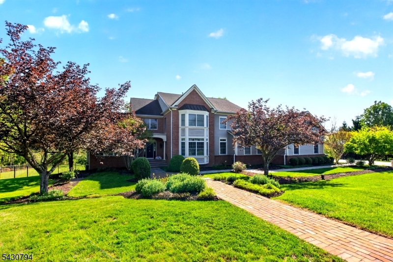 Setting a new standard for upscale living, this elegant 5-bedroom cul-de-sac residence showcases exceptional craftsmanship, expansive living spaces, and refined design throughout. Designed for both relaxation and entertaining, the backyard feels like a private resort, featuring a sparkling pool and spa accessible from the walk-out lower level. This beautifully finished basement includes a kitchenette, spacious recreation area, fitness room, billiards space, a full bath, second laundry area and storage area. Inside, the main living room is filled with natural light from dramatic sunburst windows. The formal dining room easily accommodates large gatherings, while the thoughtfully designed eat-in kitchen is ideal for everyday living, with a center island and open flow into the family room with another gas fireplace and scenic backyard views. Just off the kitchen, sliding doors lead to a stunning screened porch with a vaulted cedar ceiling-the perfect setting for morning coffee, outdoor dining, or unwinding at the end of the day. A first-floor bedroom with an adjoining full bath provides comfortable accommodations for guests. There are two dedicated office spaces, including one on the mezzanine level and another private loft space connected to the primary suite. The primary retreat includes a gas fireplace, spa-inspired bath, and walk-in closets. Three additional bedrooms complete the upper level, including one en-suite bedroom and two connected by a Jack-and-Jill bathroom.