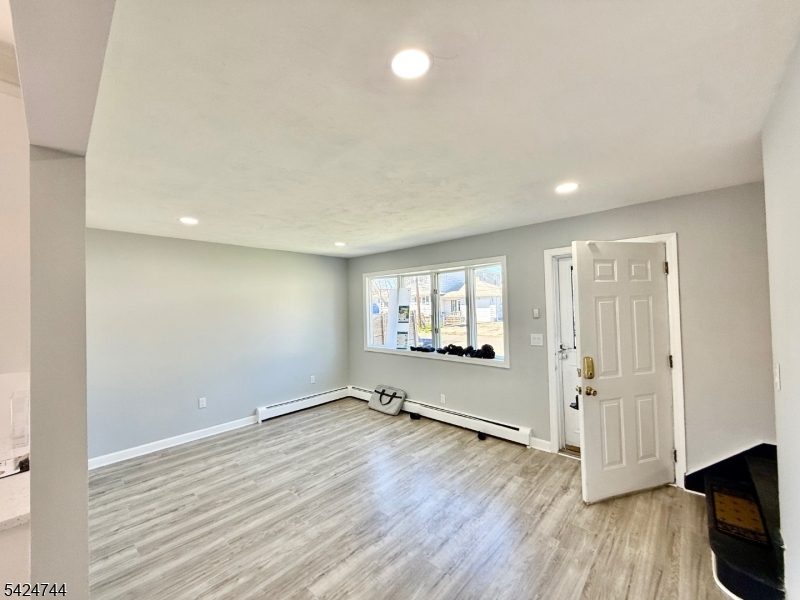 !!!PRICE REDUCED to compensate central heat and cooling!!! high and best Friday noon. Very well maintained fully renovated 5 BR 3FB home, EIK, all large rooms with plenty of closet space, large, landscaped back yard, 5 min to train close to all major highways, 3 blocks to market. Full finished basement with separate inside and outside entrance. Approx. 3,019 sq ft total finished living space (including basement). Year Built from last seller information on MLS. Prime Location Near NYC Transit, located just one block from downtown Iselin. This move-in ready home offers the perfect combination of modern upgrades, flexible living space, and commuter-friendly location, making it ideal for buyers searching for homes near Metropark train station, major highways, and NYC transportation. Brand new flooring throughout the entire home.  Fresh interior paint with modern finishes.  Updated lighting fixtures for a bright, contemporary feel.  Renovated kitchen featuring new cabinets, quartz countertops, and brand-new dishwasher, stove and gas (pending delivery). Updated bathrooms with new vanities. Flexible ground floor bedroom (currently used as dining room) Second floor with 4 large bedrooms, including one with a private balcony.    Finished Basement with Separate Entrance with excellent ceiling height, Includes 2 rooms, kitchenette, and full bathroom. Large backyard - perfect for entertaining. Two storage sheds (small and large) in matching design.