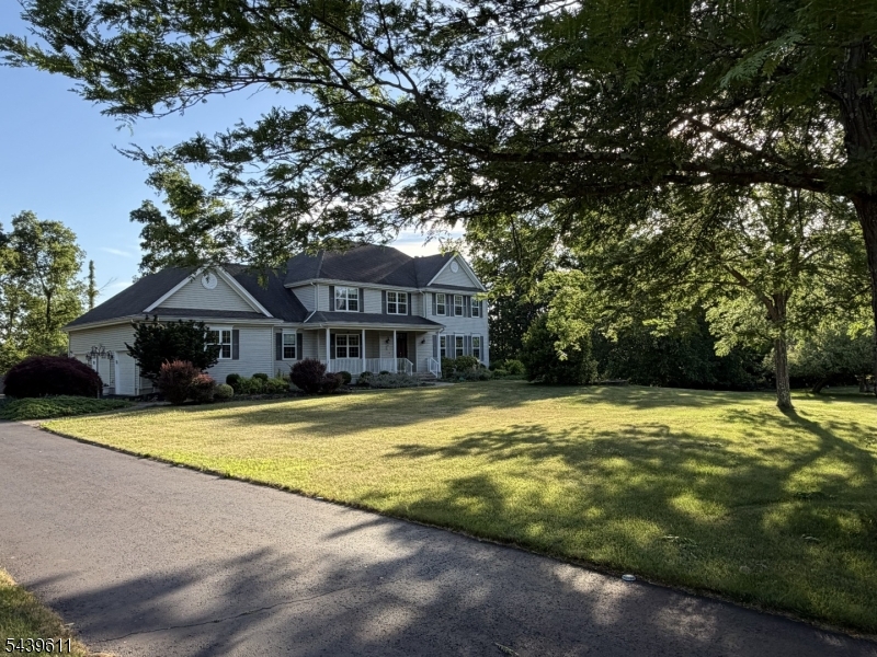 Situated on a beautiful 1.25-acre property, this impressive Center Hall Colonial offers exceptional space, comfort, and versatility for today's lifestyle. A grand two-story foyer welcomes you and is flanked by formal living and dining rooms, perfect for entertaining. The spacious eat-in kitchen features granite countertops, stainless steel appliances, double wall ovens with a warming drawer, two microwaves, a wine refrigerator, and a wet bar, and opens seamlessly to a warm and inviting family room with a gas fireplace and built-in speaker system. The first floor also includes a bedroom, laundry room, and full bathroom. A three-car garage with insulated doors and Bluetooth-enabled openers provides ample parking and storage. Upstairs, you'll find four generously sized bedrooms, including a luxurious primary suite with two walk-in closets and a spa-like bathroom featuring a soaking tub, separate shower, dual vanities, and a private water closet. One of the secondary bedrooms includes a sitting room that can easily serve as a home office, exercise room, or private retreat. The finished walkout basement adds over 1,000 square feet of living space and features a private in-law suite with its own entrance, bedroom, full kitchen, living room, laundry area, workshop, and a full bathroom with heated floors.