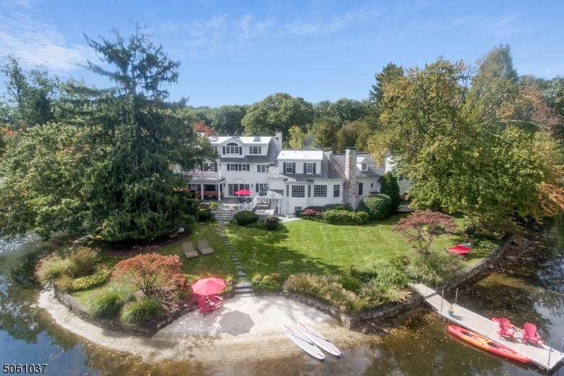 Staycation Paradise with expansive Lake views in the Mountain Lakes community with top-rated schools. Welcome to Windswept, meticulously restored and renovated for today's modern living. A sweeping driveway surrounded by greenery & tranquility welcomes you to this architecturally distinctive home framed by tall trees and lake views on three sides.  This stately Colonial offers exquisite attention to detail throughout with the finest craftsmanship, materials, millwork, moldings and cabinetry. French doors from the first floor open to an expansive bluestone patio, complete with custom outdoor fireplace and nearby hot tub. A private sanctuary with breathtaking lake views and gorgeous perennial gardens, this is a home for all seasons and every occasion.