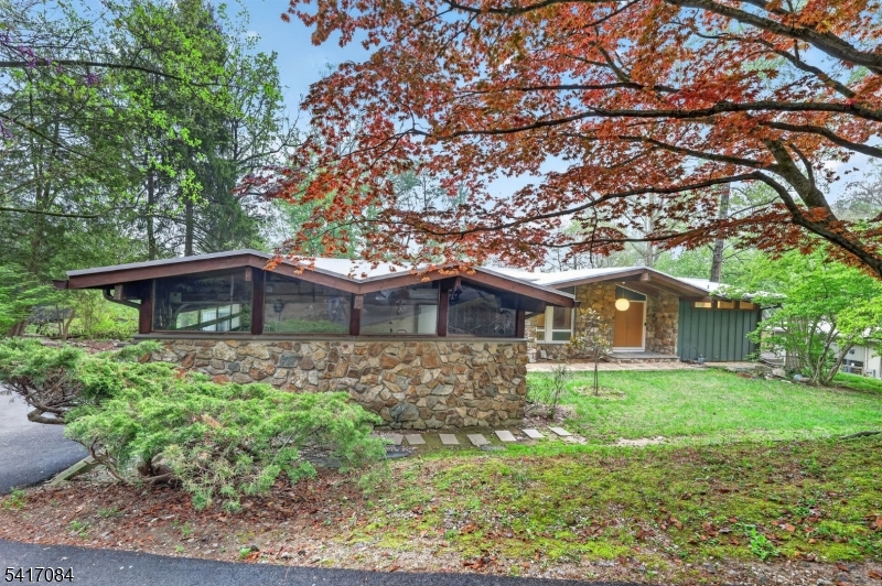 Step inside this wonderful mid-century modern home located four minutes from downtown Morristown, which was rated recently one of the top five towns to live in New Jersey. The home has been carefully restored to reflect the mid-century design. It features: mature and elevated landscaping with a brand new asphalt driveway. A look inside will reveal a grand fireplace perfect for cozy winter nights with spectacular views which change with each season. A newly designed kitchen with quartz countertop and views of the deck and scenery. The Primary bedroom reflects a en-suite shower and walk-in closet. Watch the sunrise from the Juliet-balcony. A custom two car garage with elevated custom architecture design. A true one of a kind mid century dream home!