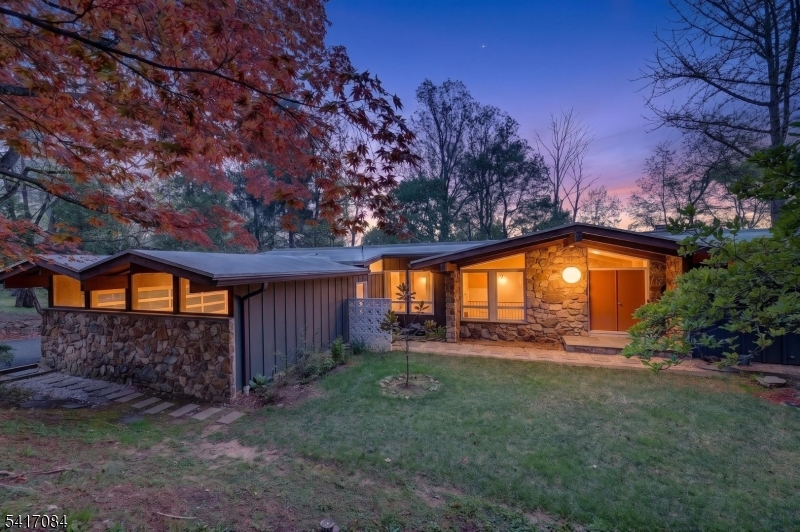 Step inside this wonderful mid-century modern home located four minutes from downtown Morristown, which was rated recently one of the top five towns to live in New Jersey. The home has been carefully restored to reflect the mid-century design. It features: mature and elevated landscaping with a brand new asphalt driveway. A look inside will reveal a grand fireplace perfect for cozy winter nights with spectacular views which change with each season. A newly designed kitchen with quartz countertop and views of the deck and scenery. The Primary bedroom reflects a en-suite shower and walk-in closet. Watch the sunrise from the Juliet-balcony. A custom two car garage with elevated custom architecture design. A true one of a kind mid century dream home!