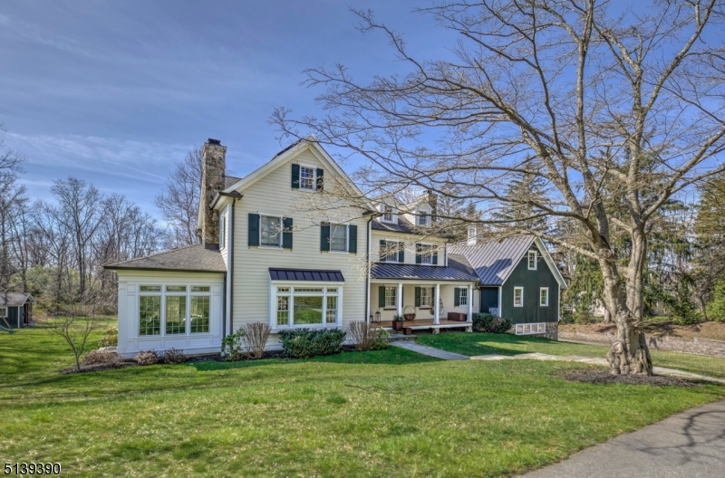 Set on over 3 acres in the heart of Basking Ridge, this modern farmhouse, custom built in 2015, is the perfect blend of function & beauty with authentic style and character at every turn. Reclaimed wide plank wood floors, abundant natural light & the finest architectural appointments throughout create a warm & inviting vibe. The well-designed open floor plan & unparalleled attention to detail on all three levels of the home is impressive. Mahogany rocking chair front porch & gracious entry foyer are reminiscent of a historic home. Dining room with fireplace boasts a fully equipped butler's pantry. At the heart of the home, the chef's kitchen with top of the line appliances is open to family room with coffered ceiling & stone fireplace. Sunroom with herringbone floor & private patio. Luxurious first floor primary suite with fireplace, balcony, room-sized WIC & spa-like marble bath with heated floors. A private office & homework nook add to the flexibility of the floor plan. Second floor features 4 ample bedrooms, 3 marble baths, laundry & walk-up attic. Open staircase leads to the fully finished walkout lower level with recreation room, full bath, wine cellar, second laundry & mudroom with built-ins. Three car garage with carriage style doors & timber cedar bracket detail. Covered deck overlooks the private park-like setting accented with pergola & tiered bluestone patio, built-in hot-tub, & firepit. Owned solar panels. Walking distance to town & award-winning schools.