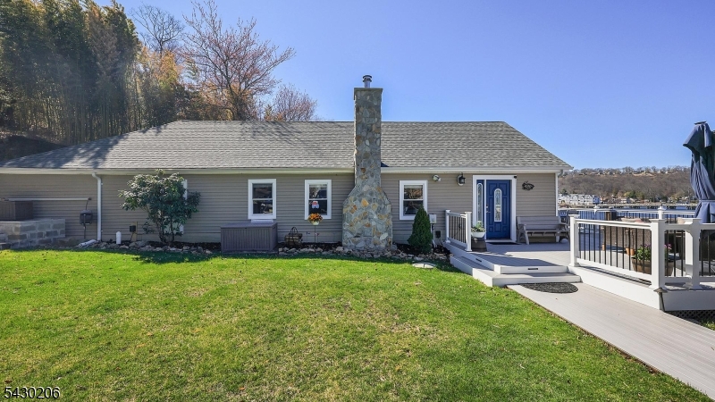 Set on the shores of Lake Hopatcong, this home delivers the lake lifestyle you've been looking for stunning views from sunrise to sunset included. Inside, enjoy high ceilings, beautiful floors, and an open layout. The updated kitchen features butcher block counters, a mosaic tile backsplash, a large granite breakfast bar, plus a double oven and cooktop perfect for everyday living and entertaining. With 4 bedrooms and 2 updated baths, there's room to grow. The primary suite offers a private bath and walk-in closet, while the loft with office space overlooks the lake ideal for working from home. Relax in the cozy family room with a wood-burning stove, or step outside to a wraparound composite deck with sweeping views, grassy yard, firepit area, and direct lake access. Notable updates include: furnace, built-in heat/AC unit, vinyl wood floors (2025), roof and siding (2021), bathrooms (2020), and a new driveway (2025) accommodating up to 7 cars. Low taxes, and easy access to Routes 80, 46, and 10 just about an hour to NYC. Move right in and start enjoying lake life.