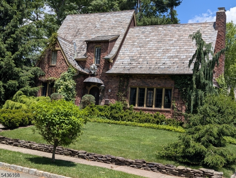 Storybook charm meets timeless elegance in this enchanting 1927 brick Tudor, tucked on a quiet street just a short distance from Nishuane Park's pool and tennis. The slate roof, ivy-draped brick, and lush, manicured gardens set a fairytale tone before you even step inside. Within, original character abounds: gleaming hardwood floors throughout, a wood-burning fireplace anchoring the living room, and exquisite leaded-glass windows and doors that fill the home with light. Three generous bedrooms and three full baths provide comfortable space, while luxe touches elevate everyday living   a serene sunroom with Jacuzzi, a jetted tub in the primary bedroom, a spa-like steam shower, and a finished basement ready for a media room, gym, or home office. The backyard is built for entertaining: a beautifully designed formal garden, a private patio, and a full outdoor kitchen for effortless al fresco dining and summer gatherings. A garage and professionally landscaped 0.17-acre lot complete the picture. All this in coveted Montclair: top-rated schools, vibrant downtown dining and arts, and an easy NYC commute. Homes with this much soul rarely come to market   come fall in love.