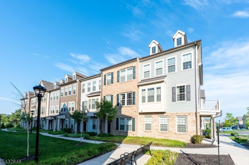 Set in the sought-after Livingston Square community, this newer 4-bedroom, 3.1-bath townhome offers one of the best combinations of style, flexibility, and low-maintenance living available in Livingston. Designed for today's lifestyle, the home spans three finished levels with 9-foot ceilings, beautiful natural light, upgraded finishes, and a smart, versatile layout. The open main level includes generous living and dining areas, upgraded wood flooring, a built-in office nook, and a private deck for indoor-outdoor enjoyment. The well-appointed kitchen showcases quartz countertops, stainless steel appliances, a large 10 foot center island, and excellent pantry storage. Upstairs, the spacious primary suite includes two walk-in closets, and a private bath with double vanities and an oversized glass-enclosed shower. Two additional bedrooms, a full hall bath, and bedroom-level laundry complete this floor. The ground level is a true game changer, offering a private bedroom or office with a full bath, ideal for guests, extended stays, or work-from-home needs, along with direct access to the attached 2-car garage. With community green space, easy access to The Mall at Short Hills, dining, parks, NYC transportation, and the express shuttle to South Orange train station, this home delivers comfort, convenience, and the best of Livingston townhome living.