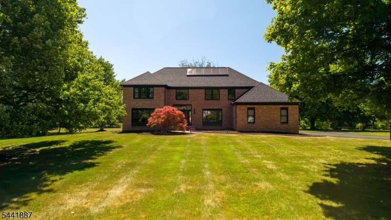 Welcome to 91 S Wiggins Lane, a 3213 sqft beautifully maintained brick front Colonial tucked away on a quiet cul-de-sac in desirable Williamsburg Estates. Situated on over 2 acres, this property is just minutes from downtown Princeton. The home is move in ready following extensive improvements; new roof, fully owned solar panels, an updated electrical panel, whole house water softener, new windows, gutters, garage doors, & multiple smart home upgrade. The interior features updated bathrooms, refinished hardwood floors across most of the 1st floor, & updated major systems such as the HVAC, WH, & sump pump. The first floor includes a flexible room perfect for a home office/guest bedroom, supported by a full bathroom, ideal for guests. The heart of the home is a dramatic family room boasting vaulted ceilings, skylights, & a wood-burning fireplace. Upstairs you'll find the spacious primary suite, three additional bedrooms, a versatile loft, & a full hall bath. The outdoor space is equally impressive, with a rear deck overlooking an expansive, private backyard. An oversized garage provides ample room for a workshop/storage, while the large basement offers endless potential for a home gym/ media room. Located within the highly acclaimed Montgomery Township School District, this premier location is perfectly positioned near top-tier private schools, shopping, dining & major commuting routes. Experience the best of quiet country living with urban convenience at your doorstep