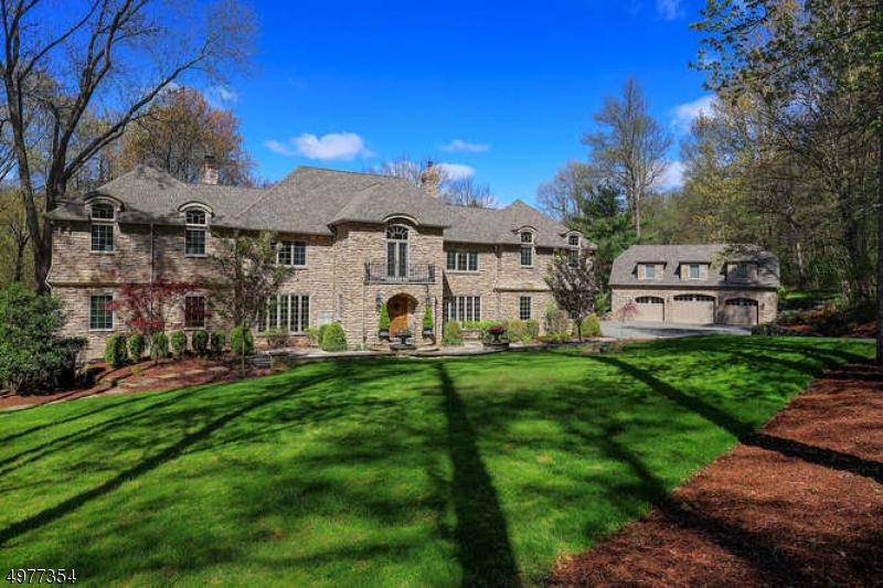 Welcome to Stonecroft--a magnificent all-stone Custom Home modeled after an enchanting French manor house replete with gated driveway, carriage house, and private pond and set back beautifully on a 6.5 acre cul-de-sac parcel in a coveted Mendham Township estate neighborhood--this remarkable, one-of-a-kind home is truly a sight to behold with over $1.7 million of recent renovations and updates.  16 rooms including 5 airy bedrooms each with en suite full bath, 3 powder rooms, 2 gas fireplaces, open floor plan family room, exquisite living room, stunning renovated designer kitchen, tasteful dining room, sumptuous primary bedroom suite, all brimming with special design features, expert craftsmanship, and unwavering attention to detail--this lovely home offers a superb floor plan and seamless flow with approximately 6,200 sq ft. of commodious living space on 3 expansive floors, plus a sprawling walk-out finished lower level and a detached carriage house with well-appointed guest/in-law suite. Spectacular stone carriage house with heated 3 car garage has a separate entrance to the 2nd floor newly renovated guest suite with spacious living room with sliding doors to private deck, complete kitchen w custom cabinetry, quartzite countertops & island seating, spacious bedroom with cathedral ceiling, full bath, laundry room with washer/dryer, plus separate HVAC system.  Main house has 2 car attached heated garage. Whole house natural gas generator.