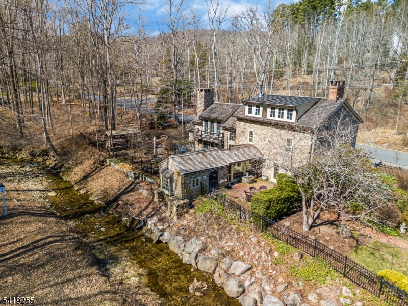 Welcome to the historic "Tory House",  a truly unique home that preserves its original character while incorporating thoughtful modern updates. Set on 3.4 scenic & tranquil acres, this distinctive home offers timeless charm, architectural detail, and everyday functionality. Classic features include exposed beam ceilings, wide-plank wood floors & striking stone walls. 3 wood-burning fireplaces add warmth & character. The kitchen is both stylish and functional, w/ pickled cabinetry & premium appliances including Viking gas stove and new SubZero fridge and dishwasher. It flows seamlessly into the dining area, highlighted by a walk-in stone fireplace. First-floor living spaces include a cozy library/office overlooking the stream and woods, a sunroom opening to two patios, and a spacious living room anchored by a 2nd stone fireplace. The 2nd level features a generously sized original primary bedroom w/ French doors, Juliet balcony & wood-burning fireplace, one additional bedroom & a distinctive main bath with stone accents. The 3rd level offers a newly converted primary ensuite completed in 2023. Outdoors, enjoy maintained gardens, winding stone paths, multiple patios, and a picturesque stream that enhance the serene, park-like setting. Additional highlights include a garage w/ loft storage, a fully equipped Sugar Shack for maple syrup production, whole house generator, top of the line septic system installed in 2016, newer roof, and a 2 story barn with storage/woodshop.