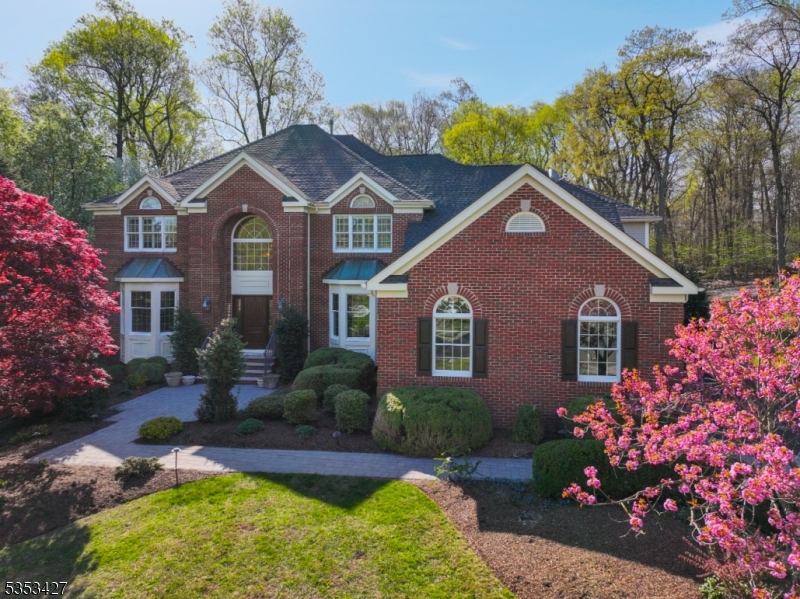 Experience 5,100+ square feet of refined living in this stunning, brick-front colonial with a 3-car garage located in the coveted Beacon Crest section of The Hills.This 5-bedroom, 4.2 bath residence combines classic architecture with timeless modern updates.Hardwood floors guide you through a thoughtfully designed layout both for everyday living and formal entertaining. Enjoy abundant light from the two-story family room with gas fireplace and statement millwork. The custom designed, sun-drenched kitchen features inlaid cabinetry, travertine floors, granite counters and professional-grade appliances. A bead board ceiling adds character to the sunroom, while the columned, two-story family room with extensive millwork provides an abundance of natural light. The butler's pantry offers exceptional functionality with wine tower, bar sink, and dishwasher. Stunning office w/ adjacent half bath offers a first-floor bedroom option. Upstairs, the luxurious primary suite features: stunning millwork, sitting area, walk-in closets, and spa-quality en suite bath. Four additional bedrooms (one currently serving as a theater room) feature Jack-n-Jill baths. The expansive walkout finished basement offers versatile spaces -studio, exercise room, game or rec room. Endless outdoor enjoyment abounds in the private backyard with custom-designed maintenance free deck and sports/movie night wall. Additional highlights include a newer roof, whole-house generator, and attached storage shed.