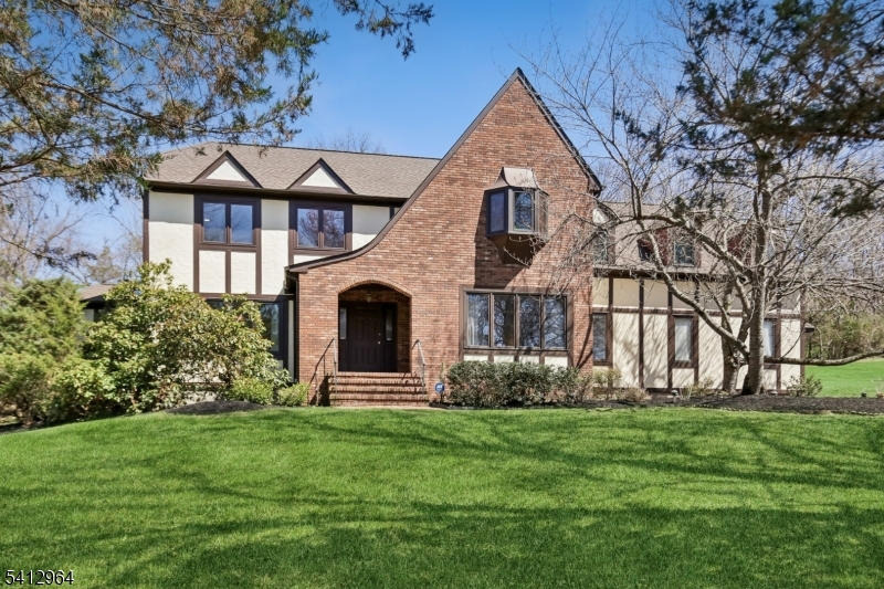 Back on the market and ready to impress. This distinctive 5-bedroom, 3-full-bath home sits on 0.88 private acres in The Summit neighborhood of Basking Ridge, offering 3,720 square feet plus a 3-car garage and a 1,879 sf unfinished basement. Hardwood floors run throughout the freshly painted main level. Six skylights flood the home with light, three solar-powered with programmable shades. The family room anchors around a gas fireplace with floor-to-ceiling brick surround. The eat-in kitchen offers granite counters, center island, gas range, and a mechanical-shade skylight. An all-season sunroom wrapped in floor-to-ceiling windows opens to the rear yard. A first-floor bedroom with closet and full bath adds flexible living on the main level. Upstairs, the primary suite features double-door entry, jetted tub, stall shower, and four closets including a walk-in. Three more bedrooms, an oversized bonus room over the garage, and a full hall bath complete the second floor. Recent updates: 2021 roof, 2024 hot water heater, nine new Pella windows, two-zone HVAC, and a repaved driveway with Belgian block border. Walk to the Lyons Avenue train station (NJ Transit) and Lakeland bus, with downtown Basking Ridge dining, parks, and shopping minutes away. Liberty Corner School, W. Annin, and Ridge High School.