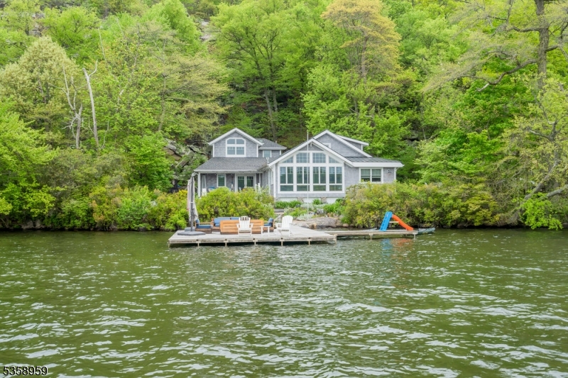 Experience modern lakefront living at 4 West Shore, ideally located in the coveted Village of Green Pond home to New Jersey's premier glacial, spring-fed lake and just one hour from NYC.Completed in 2019, this meticulously crafted residence is situated merely three doors in on the private West Shore path and ranks among only three year-round homes on West Shore. Inside, discover 4 thoughtfully designed bedrooms, a sleeping loft, and 2.5 baths. Floor-to-ceiling windows frame captivating lake views, while a striking stone gas fireplace and soaring beamed cathedral ceilings create an inviting atmosphere. At the heart of the home, the stunning center island kitchen flows effortlessly into the living areas perfect for entertaining. The private second-floor primary suite with dramatic ensuite bathroom serves as a tranquil retreat, enhancing the home's serene ambiance.Outside, a private patio and dock provide direct access to the lake, completing a lifestyle that masterfully balances luxury with the relaxed charm of lakefront living.Enjoy the privacy of lakefront living with the convenience of the Green Pond Village all in one! *Home is a legal 3 bedroom but has 4 rooms for sleeping.The beauty, tranquility and protected environment of Green Pond, New Jersey's cleanest lake, makes the location of this distinctive community ideal for year-round living or a convenient weekend retreat.  Nestled in the Morris County foothills and