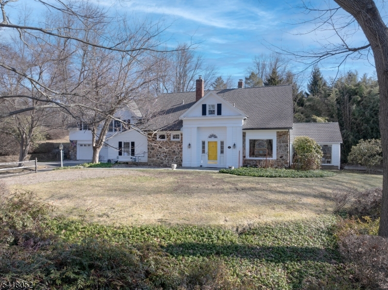 Set within Bernardsville's coveted "On The Mountain" enclave, this extraordinary residence is a rare offering steeped in architectural history and timeless charm. Originally the carriage house of famed 19th and 20th century architect George B. Post Sr.'s estate, this expanded and converted 1890s home rests on over 5 private acres, accessed by a long and winding driveway setting the tone for serenity and seclusion. History echoes throughout the home, where original stonework, century-old trees, and plantings create a rich sense of place. It beautifully balances traditional authenticity with modern elegance, offering warmth, character, and charm at every turn. At the heart of the home is a dramatic living room, offering an inviting space for both grand entertaining and quiet reflection. With over 5,000 square feet of living space and following an substantial addition, the home features five bedrooms and five full bathrooms, including a private guest suite. Outdoor living is equally compelling with seasonal views of the Somerset Hills, inground pool, and eight garage spaces for the car enthusiast, a truly rare amenity. Located just minutes from the NJT rail to NYC, shopping the the Somerset Hills Country Club, this one-of-a-kind property rewards its next Owner with a remarkable lifestyle where architectural pedigree, natural beauty, and peaceful living converge. A legacy property and a rare opportunity.