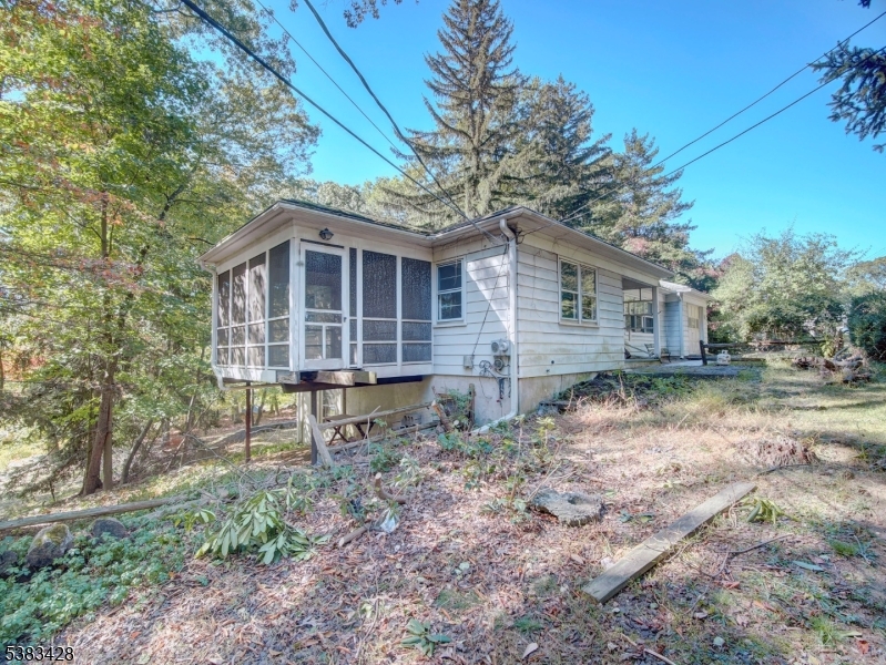 Fantastic opportunity in the desirable Stonybrook section of Rockaway Township! This 2-bedroom ranch with a den offers tremendous potential for the right buyer. Perfect for a contractor, downsizer, or first-time homeowner. Beautiful hardwood floors have been newly uncovered, adding warmth and character throughout. The inviting living room features a wood-burning fireplace, and the large kitchen and dining area provide plenty of space for everyday living and entertaining. The den is ideal for a home office or guest space. The primary bedroom opens to a bright sunroom overlooking the lake to enjoy peaceful, seasonal water views. The full walkout basement includes laundry, utility room with newer furnace, and a bathroom (water currently turned off), plus a second fireplace for future finishing potential.Set on a private .77-acre property with gas available in the street. Property and appliances are being sold as is.