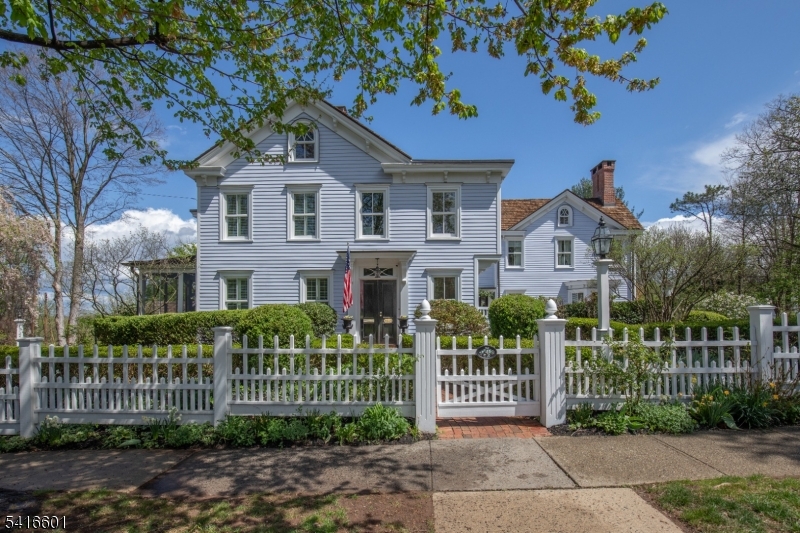 Just reduced! A must-see, in-town living with historic charm, this 5BR 1870s home has undergone a $1 million+ renovation and expansion by Scandic Builders. This turn-key home is set on just under an acre amongst English-style gardens. One barn holds a large workshop and another barn allows for recreation and games. The main home features four fireplaces and exceptional finished carpentry throughout. The soul of the kitchen is an imported Aga range, large marble island, custom cabinetry, walk-in pantry and a sun-filled breakfast room with French doors to a heated screen porch. Kitchen access leads to a private front landscaped patio. The primary suite offers cathedral ceilings, two walk-in closets, a balcony with sunrise and sunset views, and ensuite bath with walk-in shower and radiant-heated floor. Four additional  bedrooms with updated baths complete the upstairs. Open to the living area with custom bookcases and paneled fireplace, the dining room is perfect for entertaining with a butlers pantry and wet bar. A private office features a fireplace, custom bookshelves and built-ins with mahogany trim.  Walpole arbors, lighting, and a Williamsburg-style potting shed are just some of the features in the garden.