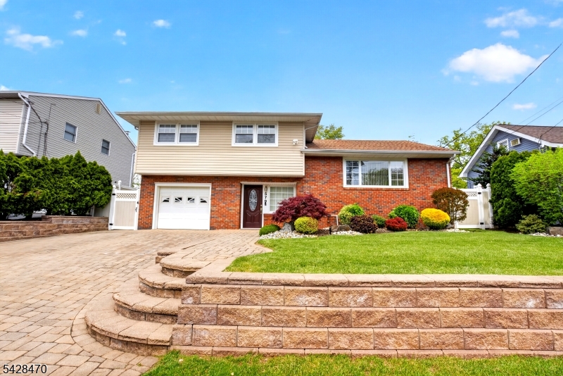 Experience this stunning 3-bedroom, 2-full-bath split-level home with attractive curb appeal that beautifully complements its staggered design. Upon entering the foyer, you'll find a spacious family room that serves as a versatile space, anchoring the home's remarkable outdoor lifestyle. The lush green lawn and well-maintained landscaping create a peaceful oasis. The backyard features patio pavers, serving as a seamless extension of the home, perfect for entertainment, relaxation, and dining just steps away from the family room entrance. The main level boasts an open-concept layout with clearly defined living spaces. Natural materials like granite countertops, wood, and ceramic flooring are paired with modern features, including recessed lighting and crown molding throughout.  Step out from the dining room onto a Trex deck that enhances the indoor living space, premium decking with superior durability designed to resist fading, staining, mold, and rot. It's designed for entertaining and allows for a smooth indoor-outdoor flow ideal for enjoying your morning coffee or evening drinks as the sun sets. The bedrooms are located on the upper level, just a few steps up from the main living area, creating a quiet retreat. The cozy lower level, often referred to as a basement, has been transformed into a functional space perfect for a dedicated theater room, cocktail bar, or relaxing lounge. Don't miss the chance to make this beautiful home yours! Schedule a private tour today!