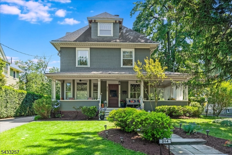 Step up to the delightful wraparound porch, outfitted with new ceiling fans, and into the grand entrance of this 1890 Victorian treasure. Take a moment to admire the rich, original oak and chestnut hand-crafted millwork, wavy leaded glass windows, beamed ceilings, carved Inglenook bench, original display cabinet, wood paneling, and decorative fireplace in the gracious foyer that flows to the elegant formal dining room and spacious living room. The swoon-worthy staircase with split landing, cozy window nook, and unpainted spindles is simply unforgettable. Classic details abound throughout: hardwood floors, custom louvered shutters, built-in bookcases, period moldings, and bright, generous windows. Central air conditioning on each floor ensures year-round comfort. The cheerful, modern eat-in kitchen features stainless steel appliances, conveniently adjacent to a first-floor laundry/mud room, rear entrance, and powder room. The second floor offers a spacious primary suite with a modern en-suite bath, three additional generously-sized bedrooms, and an updated full hall bath. The third floor provides flexible living space with a fabulous suite including a full bath, walk-in closet with custom shelving, and a bonus room perfect for a bedroom, office, or gym. Outside, enjoy a deep, fenced backyard ideal for play, gardening, or entertaining on a lovely paver patio surrounded by mature landscaping. A two-car garage and driveway with turn-around complete this very special home.