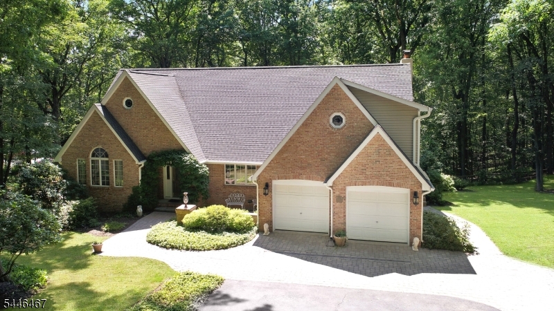 Welcome home to this custom-built Colonial, ideally situated near the end of a quiet cul-de-sac on more than five private acres. Tucked away in a serene wooded setting, this exceptional property offers privacy, expansive outdoor entertaining spaces, and an abundance of open yard for recreation. The impressive open floor plan on the main level features hardwood flooring, a den, living room, elegant dining room, and a dramatic family room with wood-burning fireplace. A versatile office, which can also serve as a bedroom, adds flexibility to the layout. At the heart of the home is a beautifully updated chef's kitchen, thoughtfully crafted by a master kitchen designer. The spacious eat-in kitchen flows seamlessly into the family room, creating a bright, connected gathering space. Upstairs, you'll find 4 generously sized bedrooms, including a luxurious primary suite with a beautifully renovated spa-inspired bathroom with heated floor. A neat extra is the balcony joining two of the bedrooms that looks out over the Koi pond and backyard. The finished walkout lower level offers exceptional versatility, featuring a private suite with full bath, kitchen, addl laundry. A spacious game room with a projector/screen provides the perfect setting for movie nights. Step outside to discover expansive decking, a patio, a large backyard, and a tranquil koi pond, creating your own private outdoor retreat. Peaceful, secluded living just minutes from Rt 80 & 1hr to NYC. Amazing Mt. Olive Schools!!!