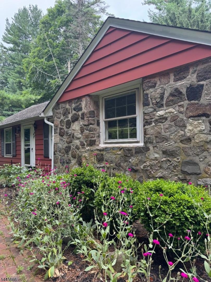 Warm, welcoming, and full of character, this Lake Mohawk ranch on a large 128 x 345 lot feels like home from the moment you step inside. Rich wood details throughout create a cozy, timeless atmosphere, complete with a lovely fireplace that adds charm to the living space. The kitchen provides ample cabinetry and an easy, functional layout for everyday living, while hardwood floors lead you into the dining room filled with natural light. The den features a second fireplace, access to the two-car garage, and a sliding door that opens to a large rear deck overlooking expansive green space perfect for entertaining, relaxing, or enjoying the outdoors. Central air adds year-round comfort. The lower level includes an additional bedroom with a full bath, a large recreation room, utility space, and walkout access to the backyard. Located in the desirable Alpine section of Lake Mohawk, this home blends character, space, and lifestyle while offering access to the scenic lake, beaches, clubhouse, and a vibrant community atmosphere. With just a little TLC, this home has incredible potential!
