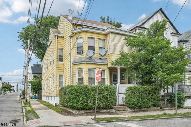 Whether you're looking to expand your investment portfolio or offset living expenses with rental income, this well-maintained 6-bedroom, 2-bathroom 2-family home offers exceptional space, versatility, and value. The first-floor unit welcomes you with a sun-filled living room featuring floor-to-ceiling windows that create a bright and inviting atmosphere. The living room flows into the dining room and office space, offering flexibility to suit your lifestyle. The spacious eat-in kitchen is appointed with custom cabinetry, granite countertops, stainless steel appliances, and a dining area. Three generous bedrooms and a full bathroom complete the first level. Upstairs, the second-floor unit features a generous living room with a cozy fireplace, custom built-ins, and large windows that fill the space with natural light. The kitchen opens to the dining room, creating an ideal setting for everyday living and entertaining. Three additional bedrooms and a full bathroom complete this level, while a covered porch provides the perfect place to unwind after a long day. A full unfinished attic and basement offer bonus storage or living space. Outside, the backyard provides space for outdoor dining, grilling, and play, complemented by ample driveway parking. Ideally located within walking distance of the Brownstone and minutes from shopping, dining, and NYC transportation, this property offers the perfect combination of comfortable living, investment potential, and commuter convenience.