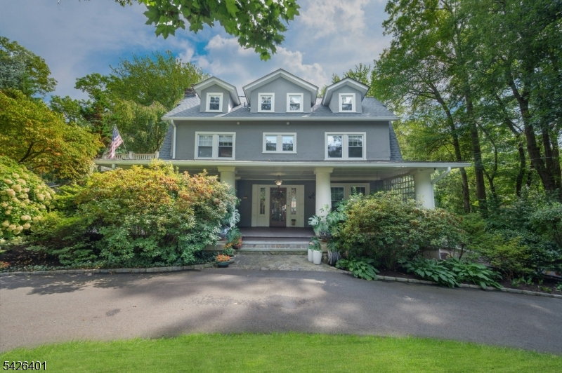 This lovingly and meticulously updated 5-bedroom craftsman colonial is move-in ready for summer. Just add memories! Located a stone's throw from the scenic cove, boating, fishing, and skating are practically at your doorstep. From the circular drive, you're welcomed by an expansive mahogany porch ready to host dinner parties for twenty! Inside, distinctive architectural details abound, including beautiful hardwood floors, crown molding, wainscoting, coffered ceilings, diamond-paned windows, charming window seats, custom built-ins, and a stunning wood-burning fireplace. A three-story addition and major renovation enlarged the contemporary style eat-in kitchen, added a new powder room and back deck, expanded a bedroom, and created a light-filled recreation room in the basement. The sunroom was also completely remodeled, ideal for a family room or office. The primary bedroom suite opens to a spacious rebuilt deck shaded by cherry blossoms, and French doors reveal a luxurious jetted tub in the primary bath. Two additional large bedrooms and bath complete this floor. The 3rd floor offers 2 more large bedrooms with gorgeous arched windows, plus a handsome new hall bath. The home has been fully insulated, and there's a brand new roof. Outside, the .6 acre carefully-curated yard blooms with color, delighting a myriad of birds, and the level backyard is ready for sports. Mountain Lakes offers top schools, 9 lakes, miles of hiking, and a welcoming community, all just 30 miles from NYC.