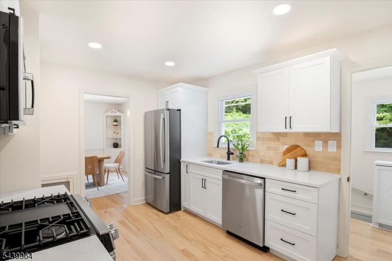 Welcome to 231 Milltown Road, a completely renovated, move-in ready home nestled in East Brunswick's sought-after Blue Ribbon school district! Every inch of this 3 bedroom, 2 full bathroom home has been thoughtfully updated with quality finishes just unpack and enjoy. Newly refinished hardwood floors flow through the main living areas, smooth freshly painted walls, fully updated kitchen and bathrooms. The redesigned kitchen features new custom cabinetry, a designer tile backsplash, and all-new appliances, making it as functional as it is beautiful. Both bathrooms have been completely tiled and updated with new vanities, mirrors, and fixtures, including a brand-new second-floor full bath adding the space and convenience today's buyers demand. Outside, enjoy a refinished rear deck, perfect for summer entertaining, complemented by manicured landscaping with trimmed shrubs, a freshened front tree, and new mulch beds that deliver outstanding curb appeal. The garage has been cleaned out and is move-in ready, and the full basement includes a washer, dryer, and utility sink - offering excellent storage or finishing potential. Centrally located with easy access to major highways, NJ Transit, shopping, dining, and parks this one truly checks every box. Don't miss it!