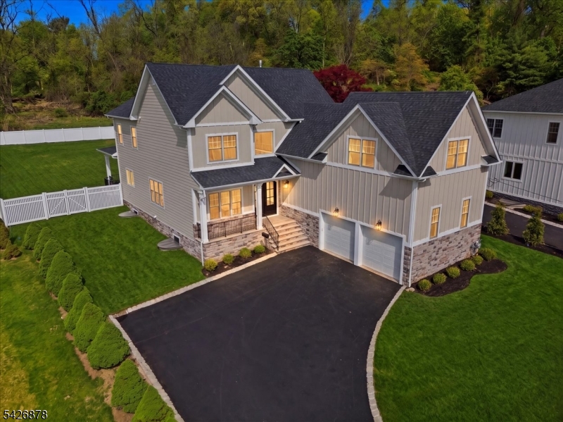 Located in the highly desirable town of Livingston, across from Hillside Elementary School, this new construction home sits on a 250-foot-deep lot with mountain views. Offering approximately 5,000 sq ft across three levels, this 6-bedroom, 6.5-bath home features thoughtful design and quality finishes throughout. A double-door entry leads to a foyer with oak herringbone hardwood flooring -- this flooring extends across the first and second levels, with LVT on the lower level. The open-concept main level with 10-foot ceilings offers a seamless flow from the foyer to a covered bluestone porch and fenced backyard. The kitchen includes stainless steel appliances, a Bertazzoni range, and a Caf  side-by-side refrigerator/freezer, and opens to the main living and dining areas--ideal for gathering. The living room features a gas fireplace and coffered ceilings, and a separate parlor provides additional living space with mountain views. The first floor also includes a guest suite, mudroom, and access to a two-car garage. The fenced backyard features a covered patio, BBQ area, and wooded setting. The second floor includes a primary suite with coffered ceilings and custom closets. The primary bath offers a soaking tub, glass-enclosed shower with multiple shower heads, marble flooring, and a private water closet. Three additional en-suite bedrooms and a laundry room complete this level. The finished lower level includes a recreation area, lounge, kitchenette, bedroom, and full bath.