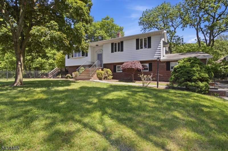 Welcome to this beautifully maintained and spacious 4-bedroom bi-level home, set on serene, park-like grounds on a cut de sac. The main level offers a bright, open layout featuring a sun-filled living room, formal dining room, and a cheerful sunroom that opens to a deck overlooking the private backyard. The spacious eat-in kitchen is ideal for both everyday living and entertaining. The ground level provides exceptional flexibility with a possible mother/daughter setup, a large family room, recreation room, versatile fourth bedroom, and a full bath   perfect for guests, a home office, or extended living arrangements. A detached carport adds convenience and extra storage. Ideally located near schools, parks, shopping, and NYC transportation, this home offers the perfect blend of space, comfort, and convenience.