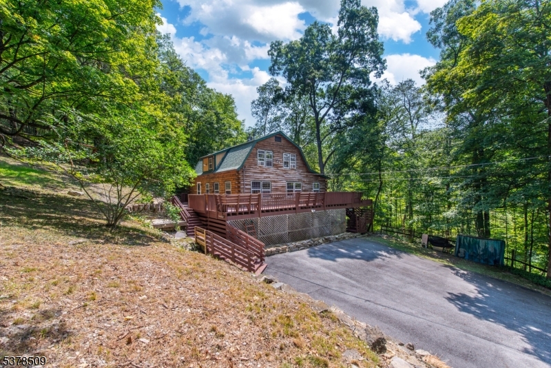 Could your next home be a log cabin in the woods?  Welcome to this charming 3-Bedroom, 2-Bath log home on 2 acres in the beautiful Frelinghuysen/Blairstown area of western Jersey.  This sturdy, well-maintained log home is situated on a private, wooded lot with its own stream! The interior is gorgeous- updated kitchen and baths, SS appliances & granite countertops, hardwood floors and oversized windows overlooking your own forest oasis!  Formal dining and large living room w wood stove, kitchen w breakfast bar and full bath comprise the first floor.  Second floor has 3 nice-sized bedrooms, walk-in closet and full bath. Walk-out basement is huge w finishable space, laundry and storage. But the deck! Newly reinforced and stained- outdoor living space at its best!  Play in the huge yard (playset included), entertain inside and out... This gem is perfect for year-round living, or a getaway any season of the year.  Move-in ready with newly updated heating system, UV water filter/softener, newer roof and new septic tank being installed!