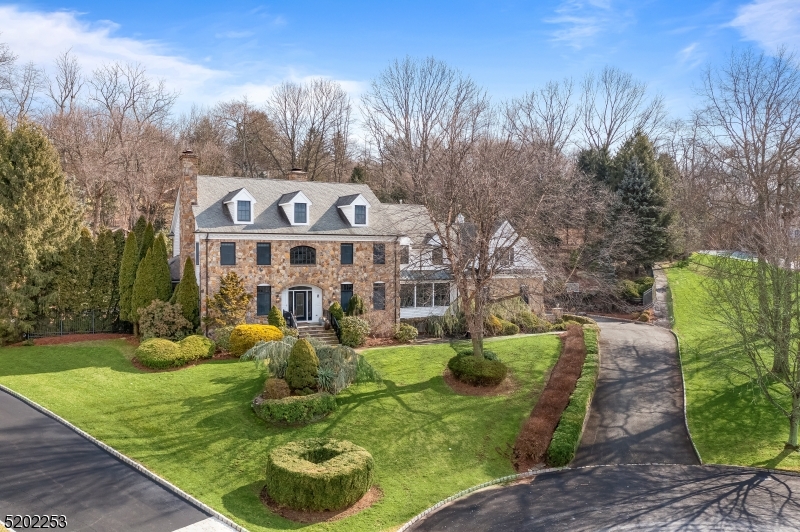 Stunning stone-front Georgian Colonial showcases a fresh, modern design aesthetic throughout its 12-room floor plan. Expansive 5 bedroom, 5.1 bath home with 3-car garage.Set on 1.1 AC of park like grounds with hillside " treehouse . Tranquil setting on a cul-de-sac with distant Mountain View. The first-floor comprises the two-story Entry Foyer with handsome staircase; fireside living room; dining room with custom moldings; butler's pantry; updated chef's kitchen with huge center-island, white wood cabinetry, quartz countertops and upper-end appliances; breakfast room warmed by a fireplace; family room with raised-hearth fireplace and built-ins; a formal powder room; solarium and enclosed porch with fireplace and hot tub. Upstairs, an expansive tray-ceiling primary bedroom is designed with a walk-in closet/dressing room and a 2021 bath featuring a soaking tub, frameless glass shower and two vanities.  This level has 3 more bedrooms and 3 full baths, laundry room as well as a huge bonus room offering a multitude of uses. A walk-up attic provides storage and utility areas. The artfully finished basement is accessible from 2 staircases. This level contains a guest bedroom, full bath, media room, exercise room and workshop.  Serving the home are multiple zones of forced-air natural -gas heat, and central air conditioning.  Minutes from schools, Midtown direct trains, golf courses, restaurants, Natirar for hiking and fine dining at the acclaimed Ninety Acres restaurant.