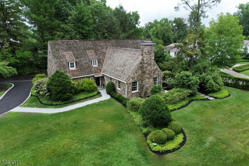 ARCHITECTURALLY UNIQUE & COMPLETELY RENOVATED * This historic Stone Manor home has been fully renovated from the ground-up and is located on one of the most prestigious streets in Short Hills. With stunning architectural details, this 5100 sq.ft. home has 6 bed, 5.1 baths, a gorgeous gourmet kitchen with separate eating area, a sunlit adjoining family room, convenient mudroom, powder room, 1st flr bedroom/office with an ensuite bath and a dramatic great room with 20' ceilings and a magnificent stone fireplace with floating mantel. UPSTAIRS: 4 bedrooms and 3 new baths include the Primary Suite with two custom walk-in closets, cathedral ceiling and a luxurious marble bath and upstairs laundry. LOWER LEVEL: 6th bedroom and full bathroom, rec room and new sauna. OUTSIDE: mature landscaping, bluestone patios and green lawns create secluded and private outdoor living spaces for entertaining or relaxing. MORE: All new plumbing, electrical, multi-zone HVAC, fixtures, finishes and appliances; 2nd laundry in basement, water softener, in-ground sprinkler system, water filter in kitchen, new hot water recirculating pump that provides immediate hot water for all baths & whole-house gas Generator. NEAR EVERYTHING: close to all top-rated Millburn Schools including Hartshorn Elementary School, downtown and the Short Hills train station with Midtown Direct service for a quick commute to NYC.