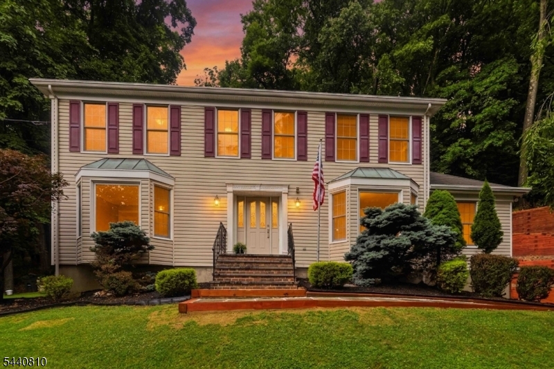 LOCATION, LOCATION, LOCATION!!  Move right into this meticulously maintained 4-bedroom Colonial home featuring a 1st floor den/office with closet, offering flexibility for guests & remote work. The beautifully renovated kitchen serves as the heart of the home and is complemented by an adjoining laundry/pantry area with floor-to-ceiling cabinetry, providing abundant storage. Hardwood floors flow throughout, connecting spacious living areas. Upstairs, the primary suite offers a private retreat with a brand-new luxury bathroom, walk-in closet, and custom floor-to-ceiling built-ins. 2 Full baths & powder room have all been completely renovated, making it truly move-in-ready! The finished lower level provides valuable additional living space and direct access to the attached 2-car garage. Outside, enjoy a private wooded setting with a spacious deck and patio designed for peaceful outdoor living. A generous driveway offers ample parking, including additional space at the lower portion of the drive. Ideally located with school bus pickup at the end of the driveway, this home offers easy access to Routes 10, 24, and 287, is less than 5 miles from downtown Morristown, and just minutes from Morris Plains town center which both offer train stations with direct service to NYC. With stunning mountain views from the front, beautifully renovated kitchen and baths, and a prime location close to shopping, dining, parks, and transportation...make this YOUR home today!