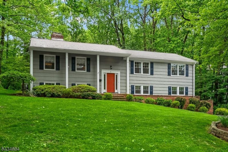 Exceptionally renovated in the heart of Springfield's Baltusrol Top neighborhood, this open, airy, & spacious home offers generous living space, thoughtful updates, resting on over half an acre. Designed for everyday comfort & easy entertaining, 4 bed, 3 full baths featuring wood flooring throughout & a bright main level where the living room, dining area, & renovated eat in kitchen flow seamlessly together. The kitchen is highlighted by a large quartz center island, premium stainless steel appliances, & a skylit ceiling that fills the space with natural light, while sliding doors lead to a grand new Trex deck with built in deck lighting overlooking the private backyard. The spacious primary suite with an outfitted walk in closet, additional reach in closet & renovated en suite bath. Two additional bedrooms share a beautifully appointed hall bathroom featuring a quartz top vanity, linen closet, neutral tile flooring, and a tub shower with subway tile surround. The finished walk out ground level provides exceptional flexibility with a family room, private bedroom, full bath, dedicated office, laundry room, mudroom space, and direct access to the backyard, as well as entry to the attached oversized two car garage. Outside, the private grounds provide an ideal setting for dining, entertaining with new front and back walkways. Conveniently located near schools, Watchung Reservation, & the Summit Train Station, this move in ready residence blends style, privacy, and convenience.