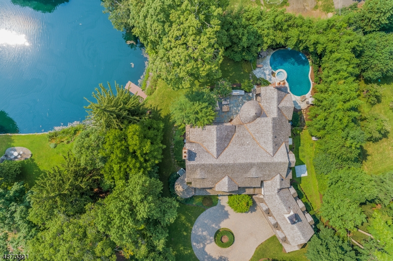 Luxury living at it's best on prestigious Dellwood Pond, this custom home with 6 bedrooms & 6.1 baths is built to the highest standards with no expense spared, just minutes to town, train & schools. Truly a once in a lifetime opportunity to own this private retreat with over 11,000 sq ft of finished open living space with great pond views & 6 bedrooms & 6.1 bath! Enjoy this banquet sized dining room, living room, 700 sq foot gourmet kitchen & breakfast room, computer room, wood paneled library, 4 fireplaces, mudroom, elevator, 2 laundry rooms, 6 beds on the 2nd level with luxurious master, lower level with large rec room, 2,200 bottle wine cellar, exercise room, game room, full bath & storage. Vacation outside with salt water pool, pond, dock & bluestone patio, 3 car garage, sprawling lawns & mature trees!