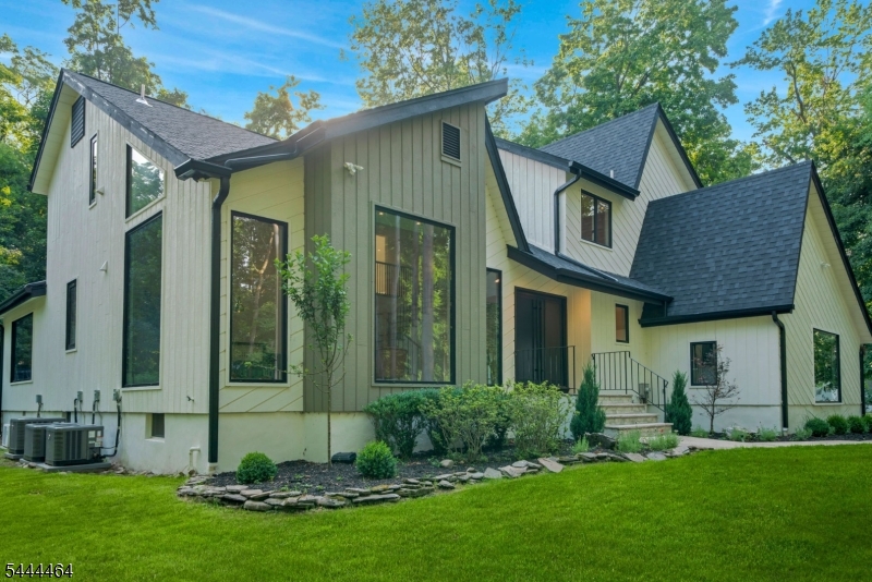 Tucked at the end of a quiet cul-de-sac and set down a long private driveway, this fully reimagined contemporary residence offers privacy and luxury. Set on over 0.85 acres of beautifully landscaped, park-like property, this exceptional home blends peaceful living with refined design and everyday convenience. Offering 2 leves of apprx 3,124 sqft plus a 1,300 sq t finished lower level, the home is filled with natural light from expansive windows and multiple skylights. A dramatic double-height foyer opens to an elegant layout designed for both comfortable living & entertaining. The chef's kitchen features TajMahal quartzite countertops and backsplash, a waterfall center island, Bertazzoni induction cooktop, two Bertazzoni refrigerators, Bertazzoni dishwasher, walk-in pantry, and abundant storage. It flows seamlessly into the dining area and inviting family room with fireplace. Upstairs are four spacious bedrooms, including a luxurious primary suite with a custom walk-in closet and spa-like bath. The finished lower level offers a large rec room, flex space, full bath, and storage. Highlights include renovated kitchen and baths, 3-zone central air, new roof, and 7.5-inch engineered wood flooring. Expansive deck overlooking serene, park-like grounds. A rare find in Haworth, this home combines contemporary architecture, luxury finishes, exceptional privacy, and close proximity to top-rated schools, premier shopping, dining, and New York.